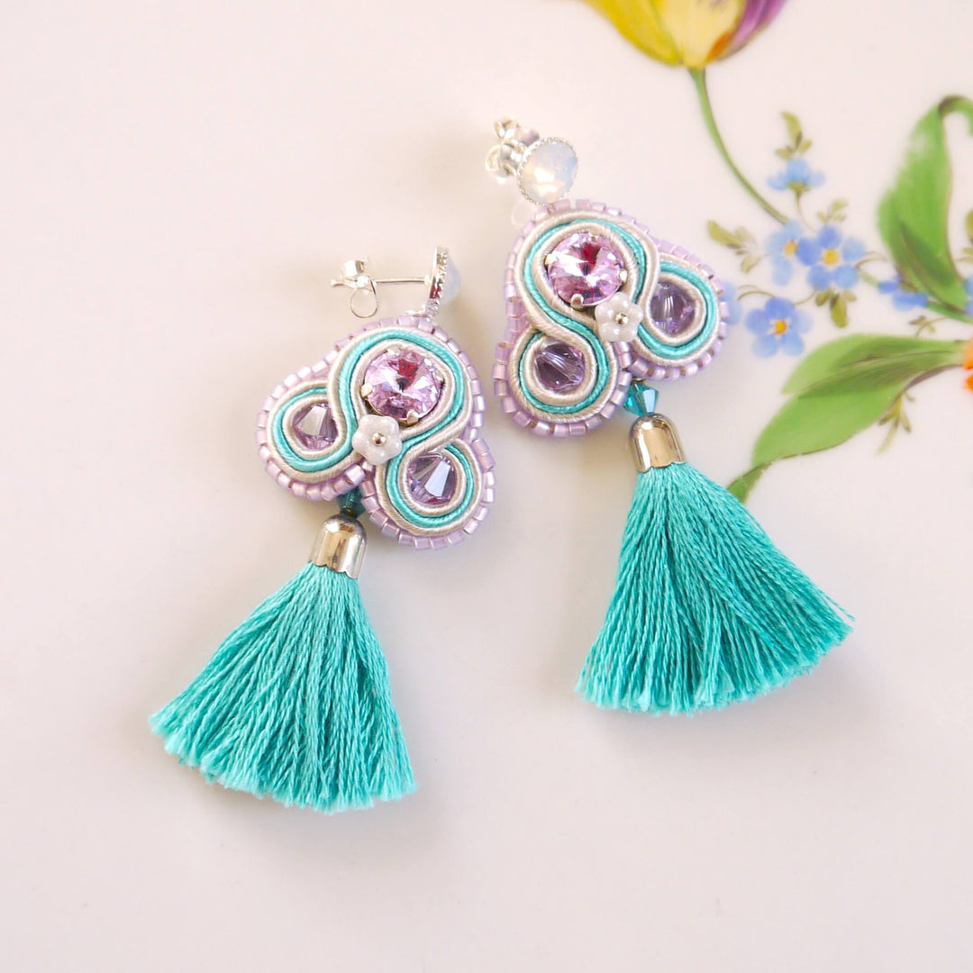 Handgenähte Quasten-Ohrringe in Türkis und Lila mit Swarovski Kristallen.